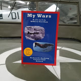 front cover of a blue paperback book with two pictures of airplanes and text